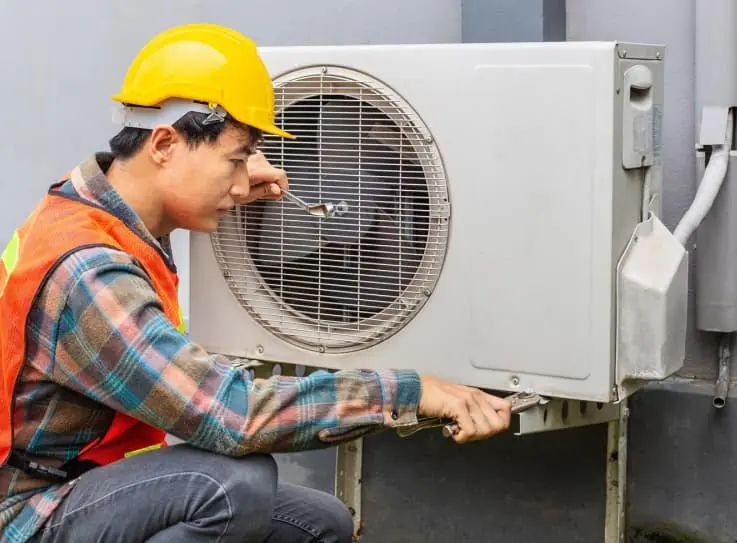 AC technician repairing an outdoor air conditioner unit in Dubai