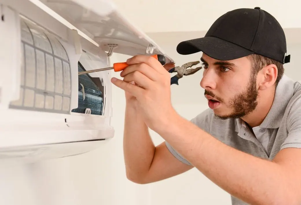 Experienced AC technician repairing a split air conditioner in a Dubai home
